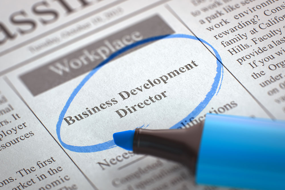 A newspaper ad for business development director circled with a blue marker