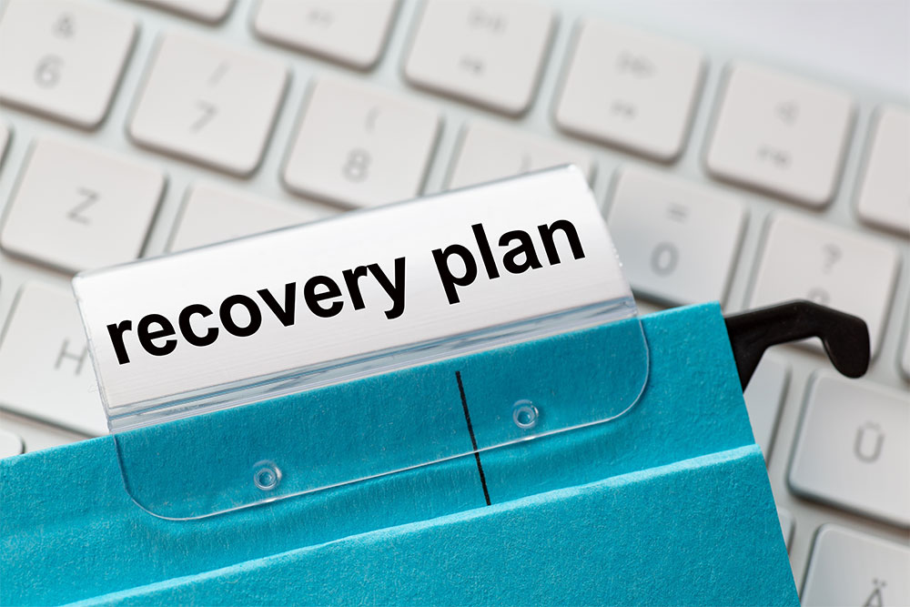 Recovery plan on a label of a blue hanging file for business turnaround strategies.