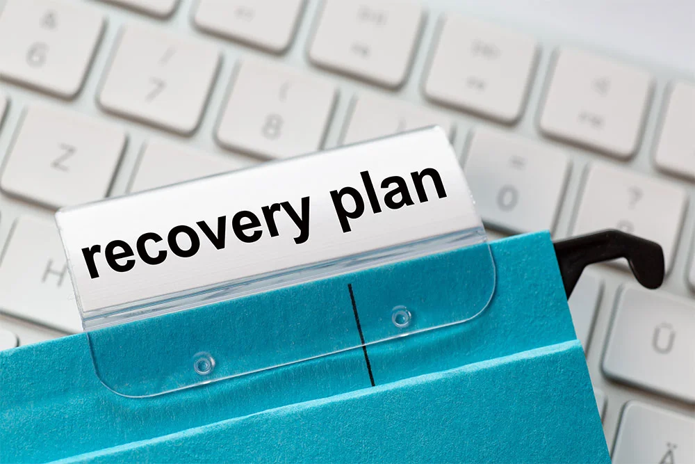 Recovery plan on a label of a blue hanging file for business turnaround strategies.