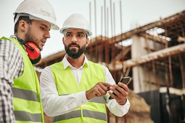 Two contructions workers talking over project plans