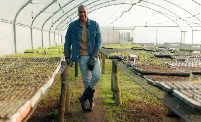 A happy farmer in a large polytunnel