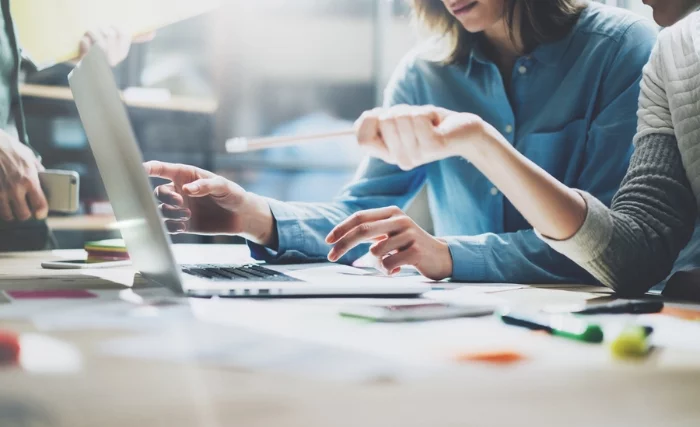 people taking part in a business brainstorm session at a laptop