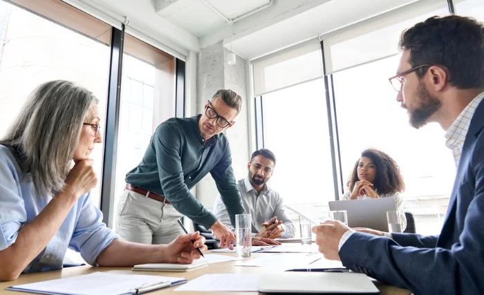 A team meets around a table to discuss the benefits of change management