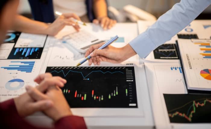 Close-up of hands analysing charts and data on printed documents during a business meeting