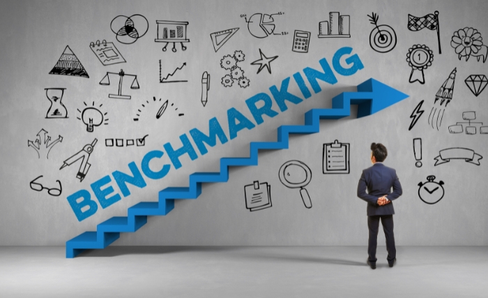 Marketing performance metrics: Illustration of benchmarking with upward steps, icons, and a business professional analysing progress