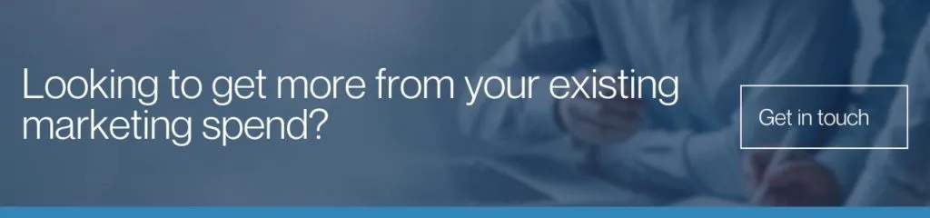 Looking to get more from your existing marketing spend: A wide banner with a dark blue overlay over a blurred image of a person writing, featuring white text reading "Looking to get more from your existing marketing spend?" and a outlined "Get in touch" button.