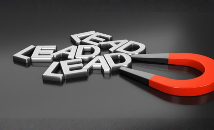 Wondering why your B2B lead generation is underperforming A banner with a dark blue background showing a blurred overhead view of people working around a table, overlaid with the text "Wondering why your B2B lead generation is underperforming?" and a "Get in Touch" button.