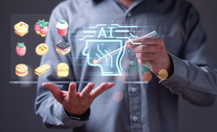 AI Strategy for Food Manufacturers: A man in a grey shirt holding a stylus over a glowing digital AI head icon, surrounded by floating illustrated icons of cakes, pastries and desserts, symbolising AI applied to food production.
